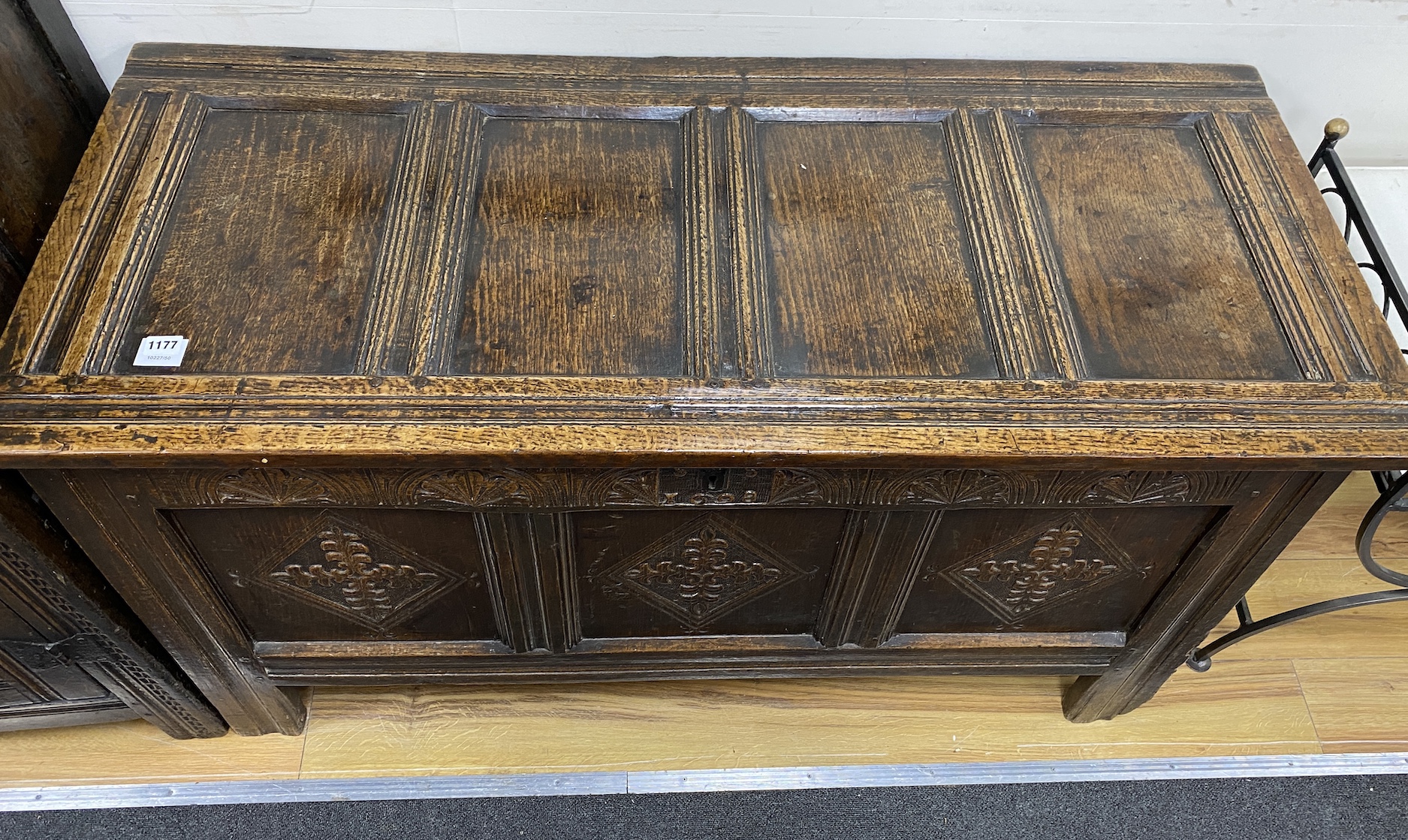 A late 17th century oak coffer, with a panelled top and lozenge carved front, length 128cm, depth 56cm, height 70cm